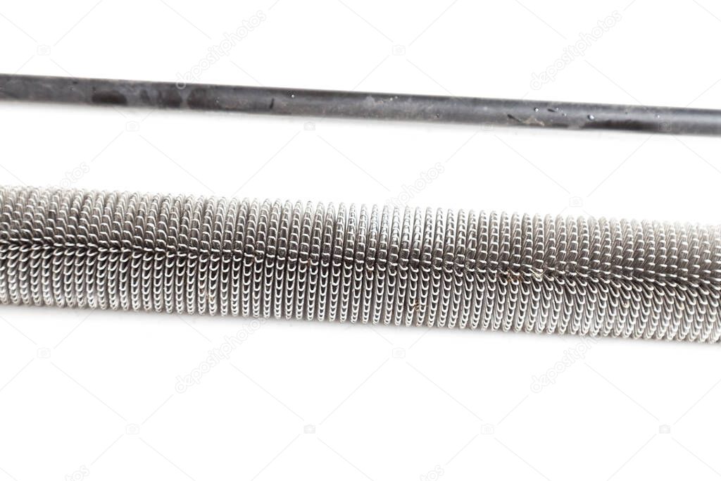 Close-up of a tube of an aluminum radiator with twisted coils on a white isolated background in a photo studio for a catalog or sale of spare parts.