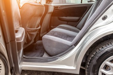 Arka koltuklarda koyu gri kuru temizleme kumaşına döşenmiş eski bir Japon arabasının satış öncesi hazırlığı..