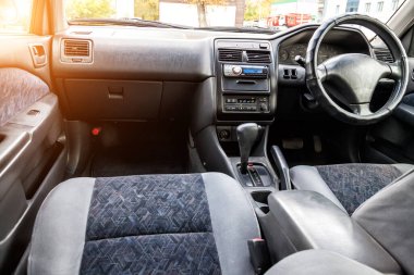 Konforlu ön koltuklar ve direksiyon arabanın içinde: sürücü ve yolcu, gri kadife ile bağlanmış, modern iç tasarım.