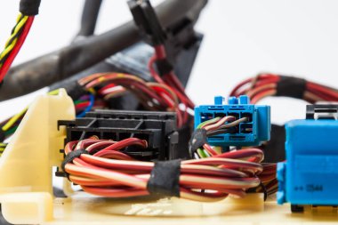Arabanın elektrik kablolarında konnektörleri olan farklı renkte mat kablolardan oluşan bir kablo. Tedarikçinin çalışmasında internet hattı.