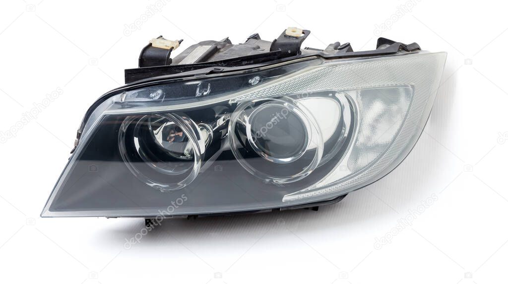 Stylish xenon right headlight of a German car - optical equipment with a lamp inside on a white isolated background. Spare part for auto repair in a car workshop.