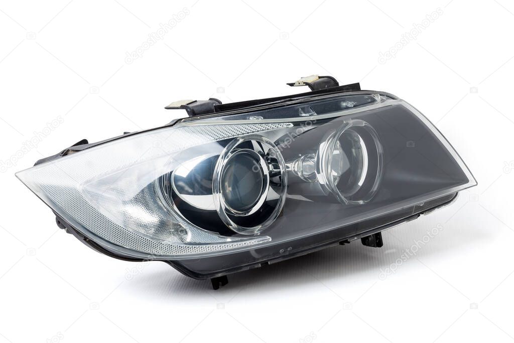 Stylish xenon right headlight of a German car - optical equipment with a lamp inside on a white isolated background. Spare part for auto repair in a car workshop.