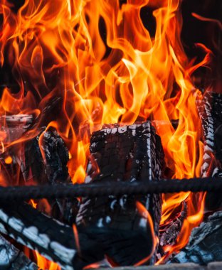 Tuğlalı, dumanlı bir barbekü sobası. Kırsal kesimde bir yaz haftasonu kömürleşmiş odun odunlarından çıkan alevli şişler için demir çubuklar..