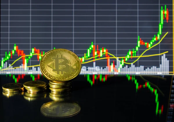 Altın bitcoin tablet cam zemin üzerinde hisse senedi grafiği önünde. Karanlık, bokeh, bulanık kavramı.