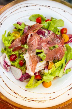 Masada beyaz tabakta ördek salatası füme.