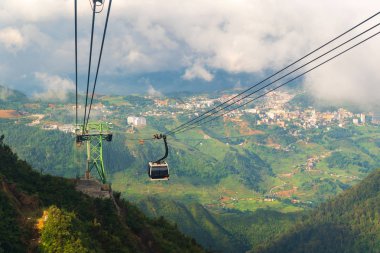Cable car In the middle of the valley, fog in cloud background of country in Fansipan mountain SAPA VIETNAM. clipart