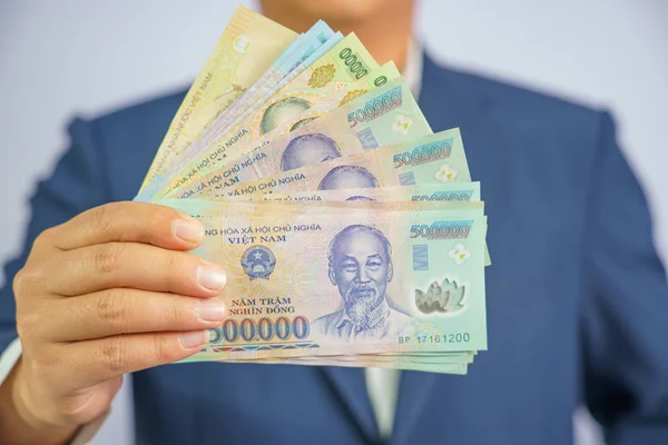 Vietnam 'da para mavi bir takım elbise giyen el iş adamı tutun (
