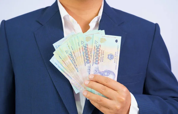Geld in Vietnam hält Geschäftsmann im blauen Anzug in der Hand ( — Stockfoto