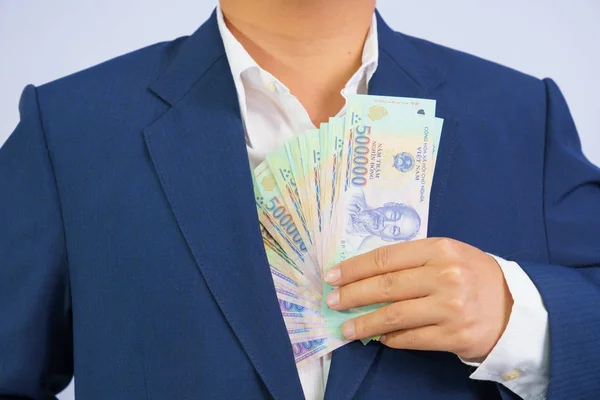 Geld in Vietnam hält Geschäftsmann im blauen Anzug in der Hand ( — Stockfoto