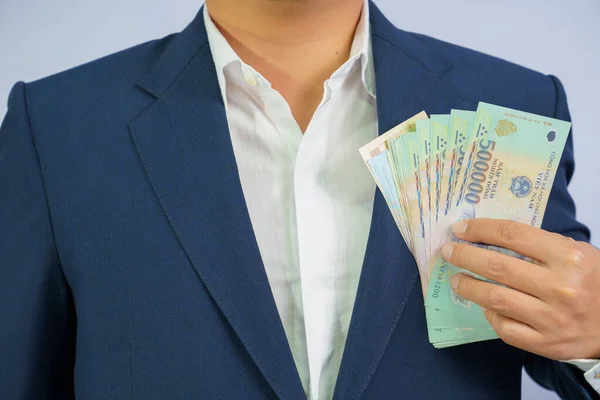 Geld in Vietnam hält Geschäftsmann im blauen Anzug in der Hand ( — Stockfoto