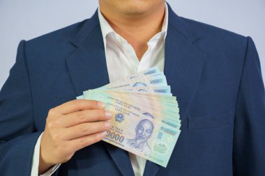 Vietnam 'da para mavi bir takım elbise giyen el iş adamı tutun (