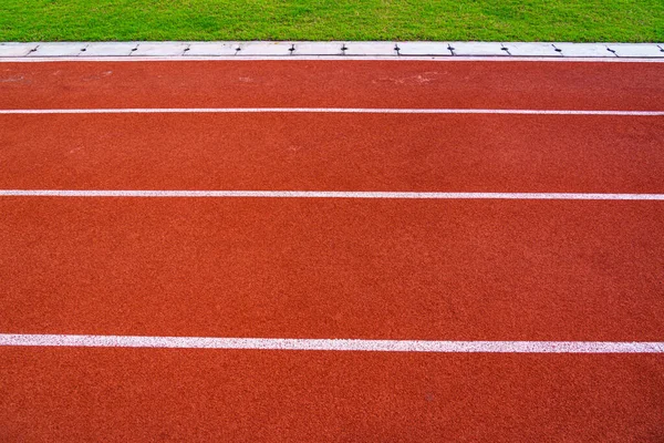 Red running track with white lines in outdoor sport stadium, sid