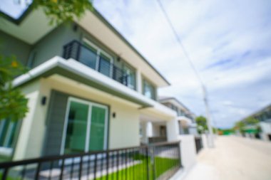 Geniş, büyük, pahalı, lüks köylerde ya da modern evlerde soyut beyaz bulanıklık ve bokeh konutlar ve küçük yol. Evin yanında yeşil bir bahçe var..