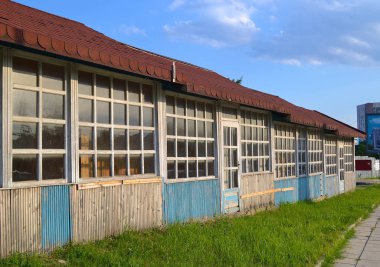 Tek katlı ahşap bina kahverengi renk ortak bir çatı altında bir satır. Onların büyük pencereler ve kapılar üst kısmı, birçok küçük camlar ahşap bağlama oluşur