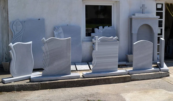 A small private firm that produces gravestones exposes samples of its products along the sidewalk. Varna, Bulgaria