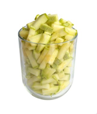 Beyaz bir arka plan üzerinde izole şeritler halinde kesilmiş kabak ile dolu saydam cam Kupası