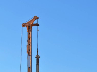 Arka plan mavi yaz göğün, kopya alanı üzerinde sarı kazık sürücü (üst kısım) 