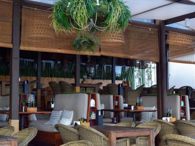 Bir yaz sabahı ilk ziyaretçiler için bekleyen bir gölgelik altında sokak açık kafe