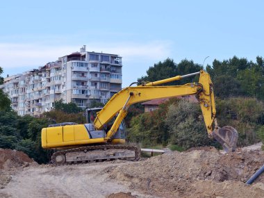 Yol inşaat çalışmaları konut binası, yan görünüm, yaz, gün yakınındaki sitesinde sarı Ekskavatör