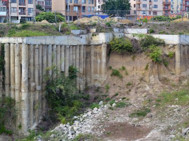 Terk edilmiş inşaat site üzerinde Genç ağaçlar ve çalılar büyümek şehir, yaz, gün içinde yüklü yığınları ile