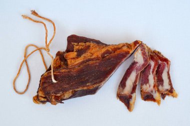 Parça ip ve tarafsız arka plan üzerinde birkaç dilim asma Kurutulmuş domuz pastırması kapatmak kadar üstten görünüm