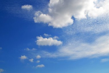 Bir sürü beyaz bulutlar farklı türlerde: cumulus, cirrus, katmanlı yüksek mavi gökyüzünde güneşli bir günde