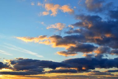 Gri-mavi bulutlar mavi gökyüzü gün arka plan üzerinde sarı güneş tarafından aydınlatılmış