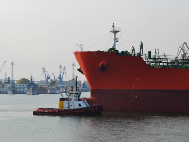 Küçük bir pilot gemi büyük kırmızı kargo gemisi liman rüzgarsız sıcak üzerinde bir sonbahar günü yol açar