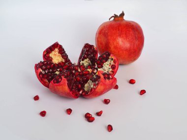Kırmızı yemeye hazır olgun sulu nar meyve tohumları üzerinde beyaz bir arka plan ile yakın çekim