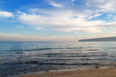 Atmosferik deniz manzarası. Beyaz bulutların üzerinde bir ışık akşam sis, yumuşak odak sakin kış denizde mavi gökyüzü.