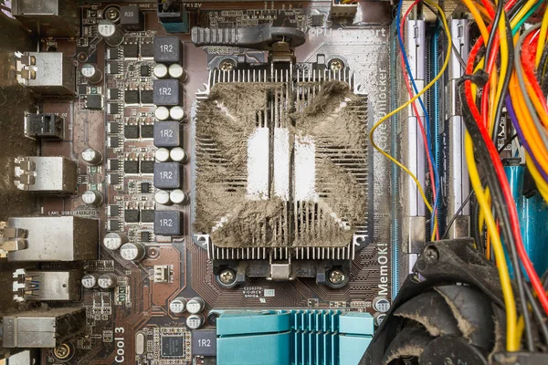 Cooling radiator over the cpu covered with a lot of dust. View from inside the case of a personal computer on a dirty pc hardware.