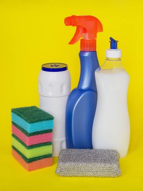 Deterjanlar, mutfak için üç tür: sprey ve toz ve renkli köpük sıvı, sünger sarı bir arka plan üzerinde bulaşık için. Mutfak deterjanı. Ev kimyasalları. Ev işleri. 