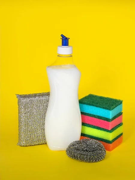 在黄色背景上的洗碗液和三种不同硬度的海绵 厨房洗涤剂 家用化学品 — 图库照片