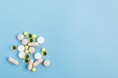 Bir yığın farklı hap ve kapsül mavi bir arka plan üzerinde. Hasta olmak için hap almak veya tedaviyi. Sağlık ve ilaç kavramı. Yat, yukarıdan görüntülemek, alan kopya.
