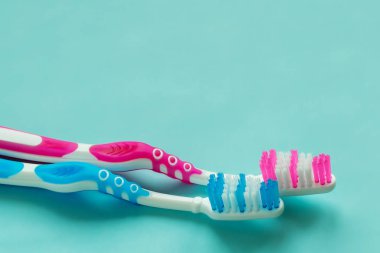 Mavi bir arka plan üzerinde mavi ve pembe diş fırçaları alanı kopyalayın. Günlük diş bakımı, ağız hijyeni, diş ve diş eti, sağlık, hastalıkların önlenmesi kavramını.