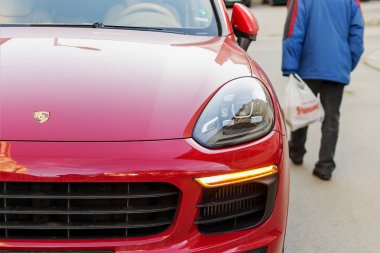 Varna, Bulgaristan, 28 Şubat 2019. Komuta sizde yürüyüşler kırmızı bir Porsche araba geçmiş sokakta kötü giyinmiş. Lüks ve yoksulluk kavramı. Yoksulluk ve zenginlik kontrast.