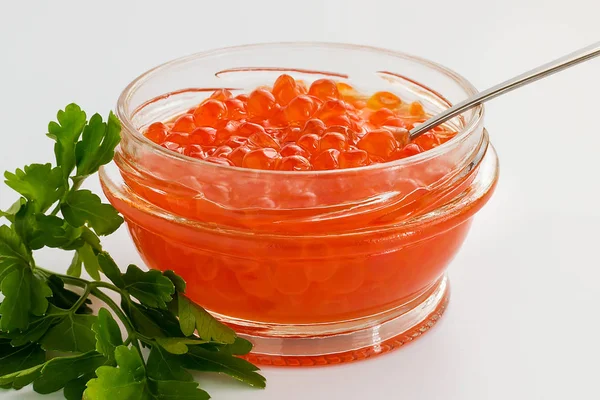 A glass jar of red caviar on a white background. Salmon caviar. Sea fish delicacy. View from above.