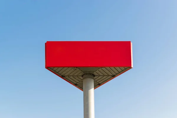 Empty red billboard with copy space on the background of a blue sky. Red mockup with place for your text. Large banner mockup for advertisements.