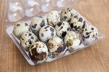 On iki Bıldırcın yumurta bir şeffaf plastik ambalaj içinde benekli.