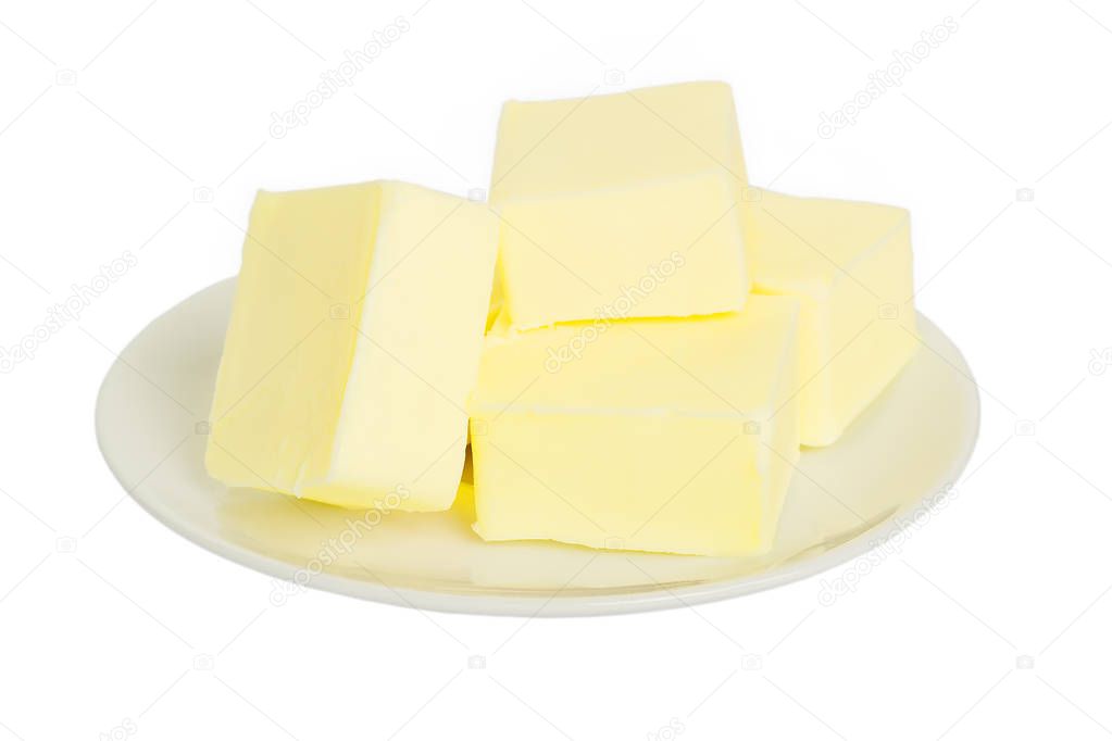 Close-up of fresh butter pieces on a white plate. Isolated.