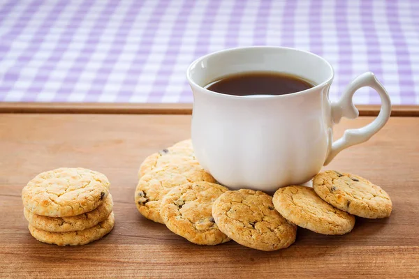 White porcelain cup with tea and sweet oatmeal cookies — Stock Photo, Image
