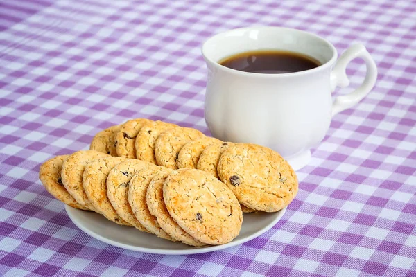 Copa de porcelana blanca con té y galletas de avena dulce — Foto de Stock