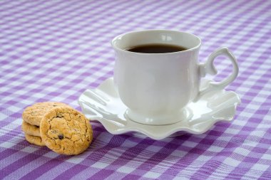 Üzerinde bir fincan çay olan beyaz porselen tabağı..