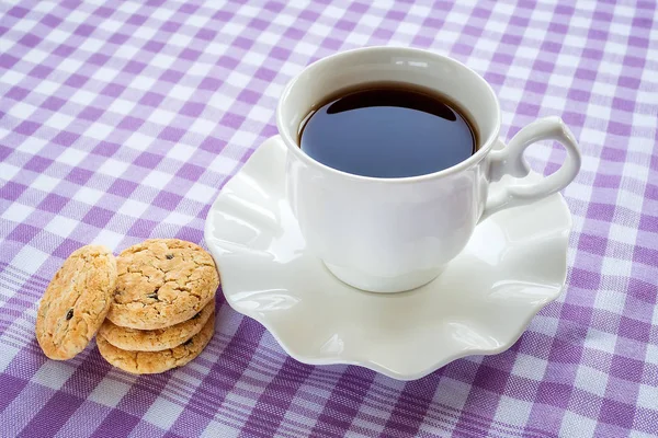 White porcelain saucer with wavy edge with cup of tea on it.