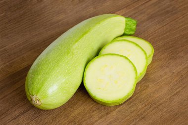 Bir taze yeşil kabak ve ahşap kesme tahtası üzerinde birkaç dilim