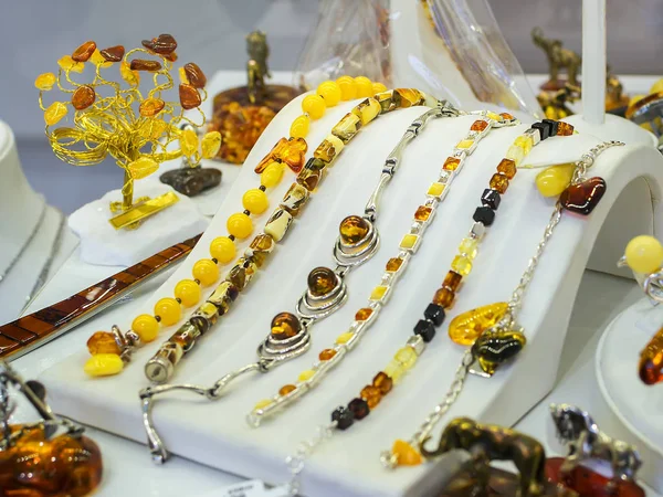 Bir kuyumcu vitrin beyaz bir stand üzerinde Baltık kehribar takı bilezik.