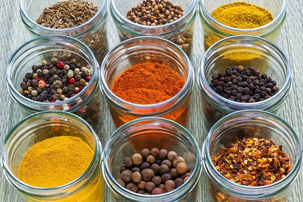 Set od nine different spices and herb seasonings in a glass jars