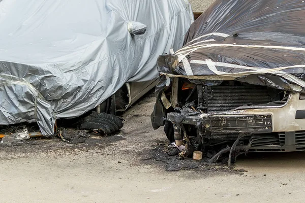 Dvě auta zničená ohněm na městské ulici — Stock fotografie