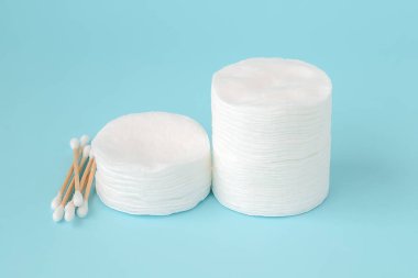 Yuvarlak pamuk pedleri ve ahşap sopa pamuk tomurcukları yığını mavi iki yığın