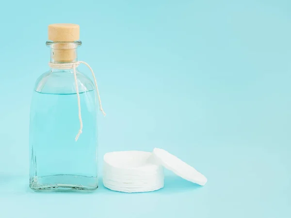 Tónico para la piel de la cara o removedor de maquillaje en una botella de vidrio y almohadillas de algodón — Foto de Stock